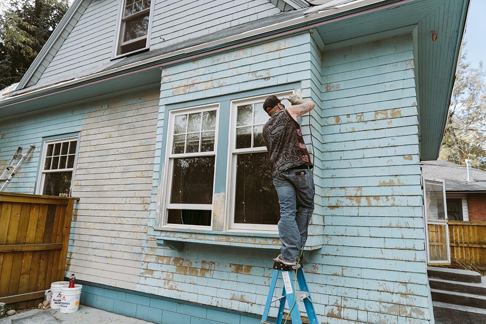 Man doing renovations on the exterior of a house